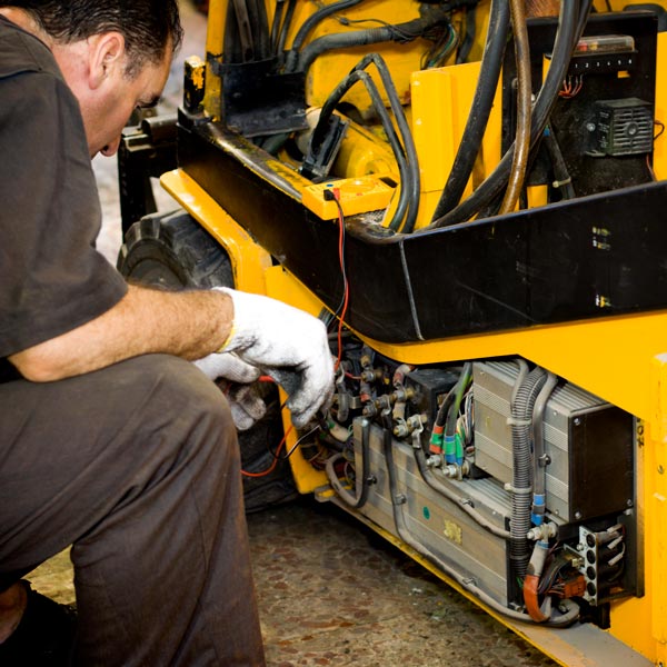 man repairing forklift